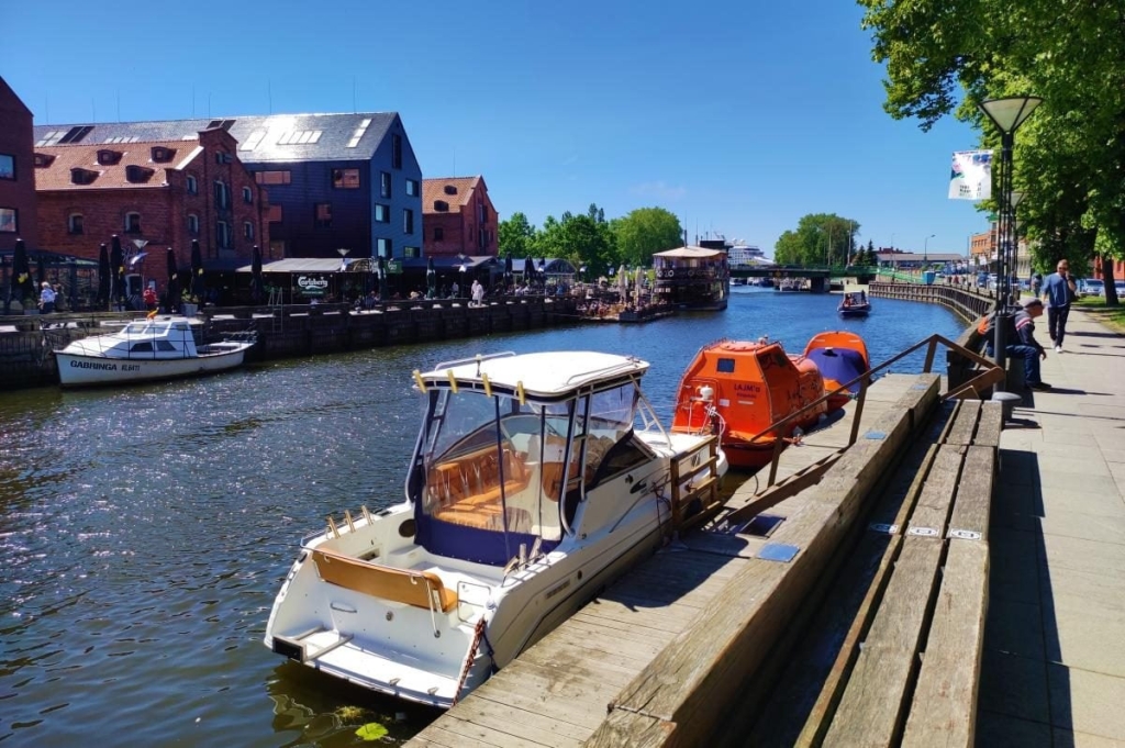 Історія Клайпеди Магазини та кафе у центрі Клайпеди з туристами, що досліджують історію міста у 2026 році.