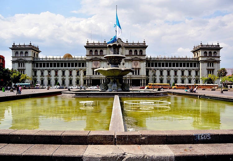 Гватемала: барвисте місто Кольорові будинки у Гватемалі з вулканом на горизонті, типовий клімат Гватемали